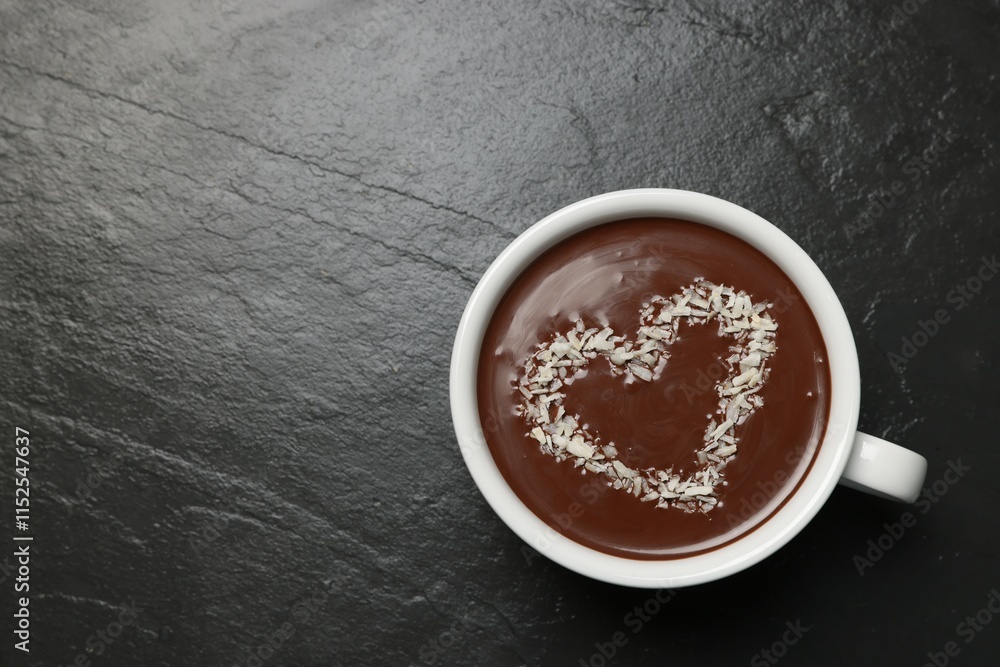 Cup of hot chocolate with heart shaped decoration on black table, top view. Space for text Cup of hot chocolate with heart shaped decoration on black table, top view. Space for text