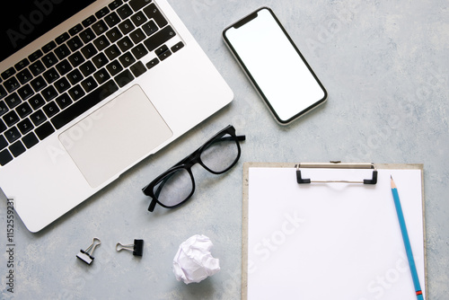 Tableau sur toile Gray desk office with laptop, smartphone, glasses and other work supplies