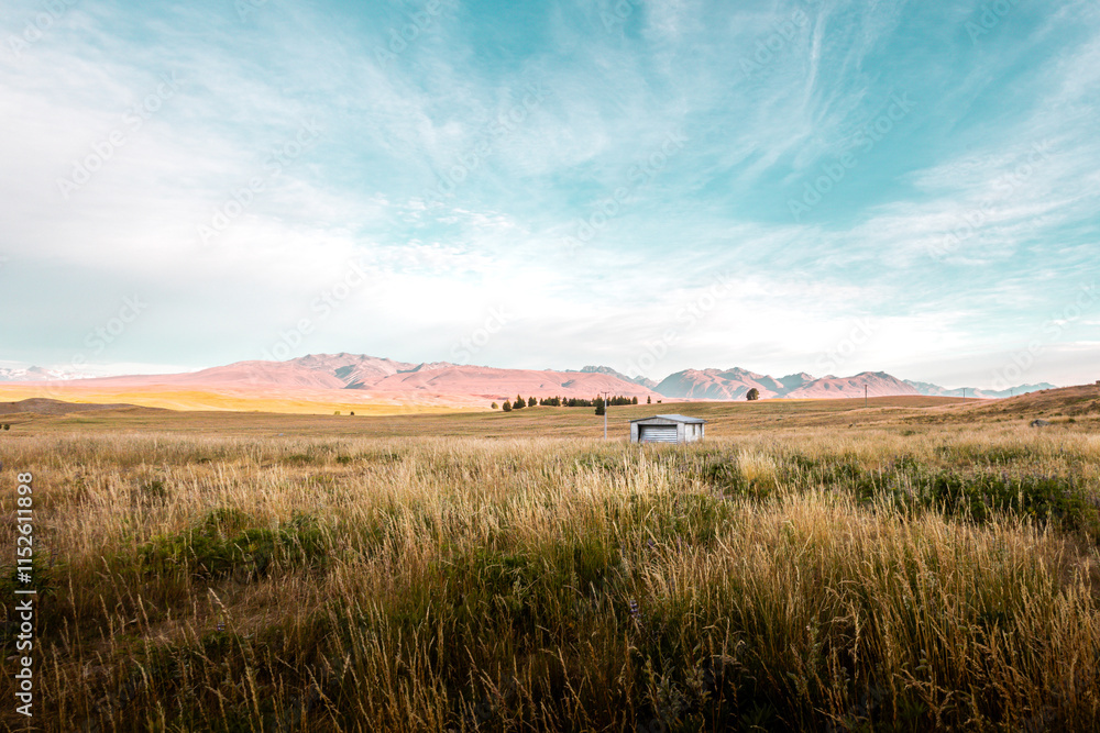 Rustic Shelter Amid Golden Plains with Majestic Mountain Backdrop Rustic Shelter Amid Golden Plains with Majestic Mountain Backdrop