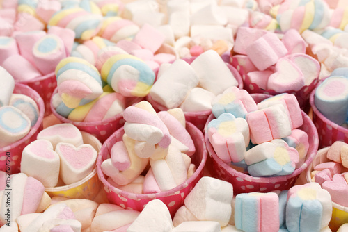 Confectionery and sweeties varieties background: light pink and white marshmallows, sugar confetti, bonbon and candies, selective focus, shallow focus photo