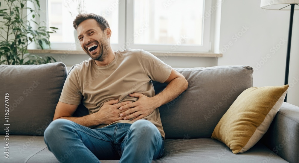 Caucasian man sitting on couch, laughing heartily Caucasian man sitting on couch, laughing heartily