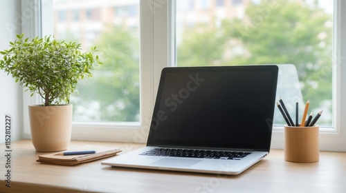 Wallpaper Mural Modern workspace with laptop, plant, stationery, and sunlight streaming through a window in a cozy atmosphere Torontodigital.ca