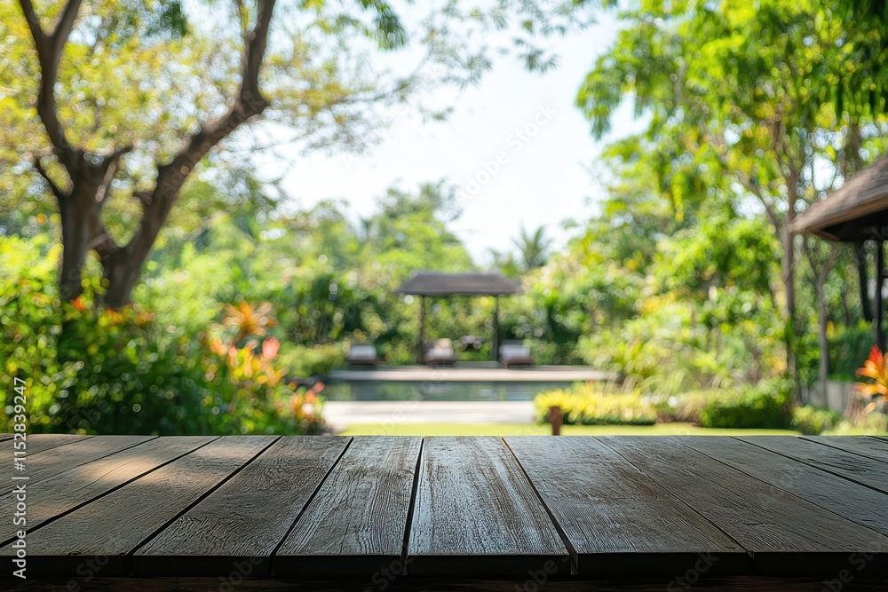 Wooden table overlooking a tranquil garden with a pool and gazebo. Wooden table overlooking a tranquil garden with a pool and gazebo.