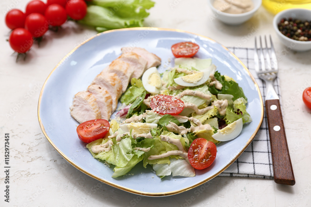 Plate of tasty chicken Caesar salad with tomatoes and bowl of peppercorn on white background Plate of tasty chicken Caesar salad with tomatoes and bowl of peppercorn on white background