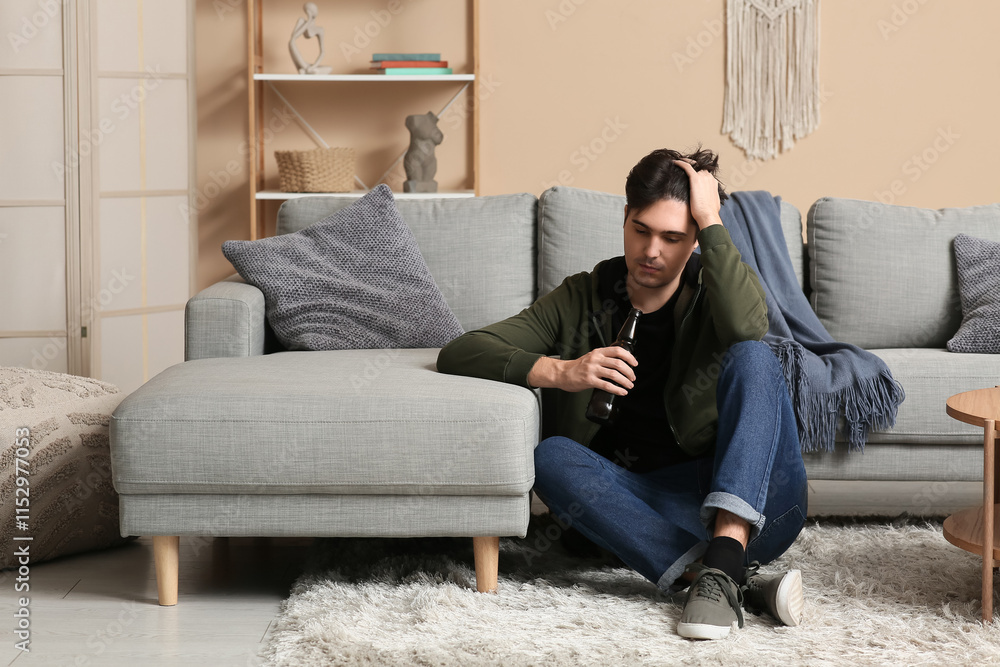Depressed young man with beer sitting at home Depressed young man with beer sitting at home