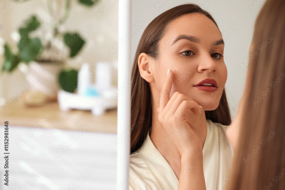 Young woman applying pimple patch near mirror in bathroom, closeup Young woman applying pimple patch near mirror in bathroom, closeup