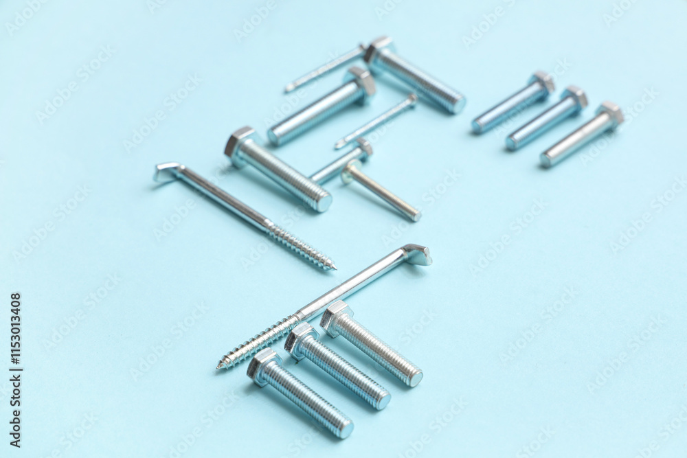 Arrangement of different tap bolts and hex keys on blue background Arrangement of different tap bolts and hex keys on blue background