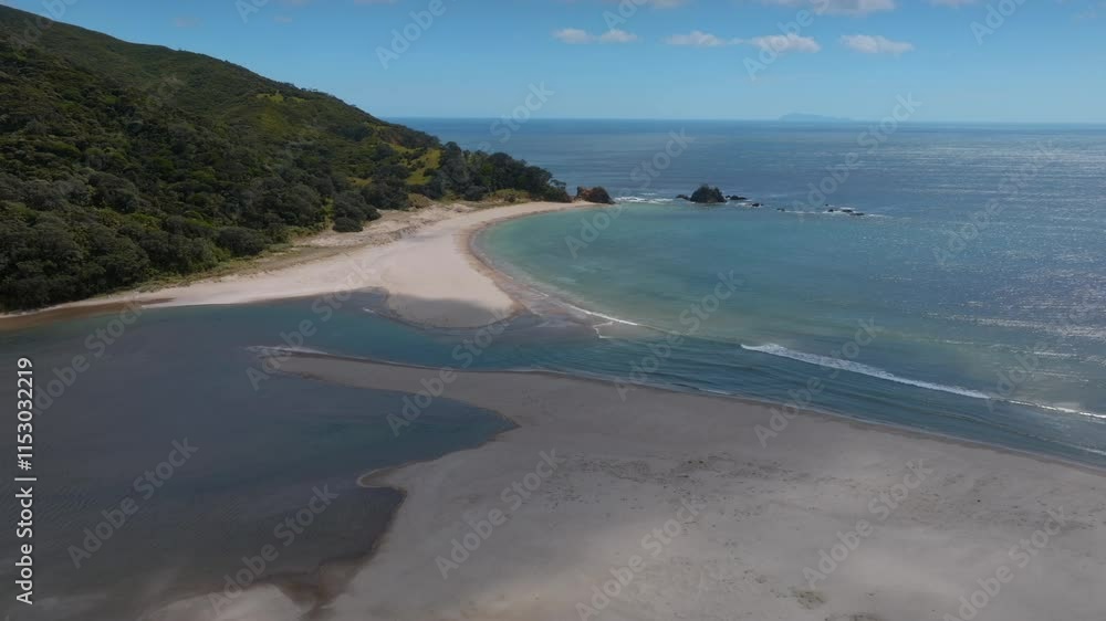 Aerial view of a pristine beach meeting the ocean. Coastal landscape with sand, water, and lush green hills. Beautiful New Zealand scenery. WAIKAWAU BAY, COROMANDEL PENINSULA, NEW ZEALAND Aerial view of a pristine beach meeting the ocean. Coastal landscape with sand, water, and lush green hills. Beautiful New Zealand scenery. WAIKAWAU BAY, COROMANDEL PENINSULA, NEW ZEALAND