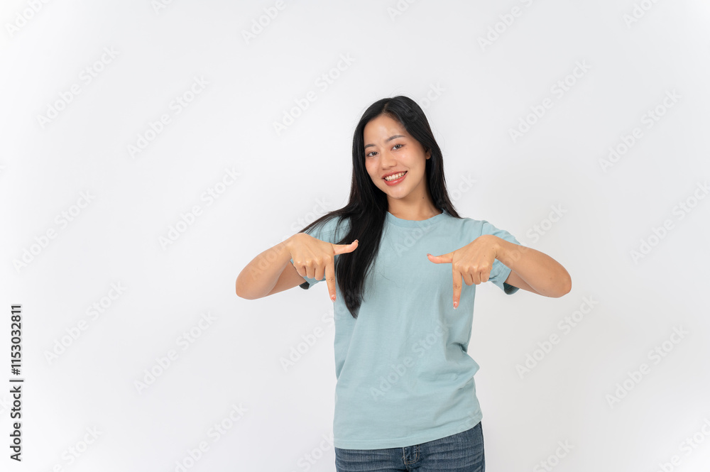A woman standing on a studio background, pointing her finger downward as she recommend something. A woman standing on a studio background, pointing her finger downward as she recommend something.