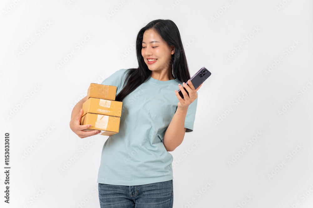 A smiling woman standing against a white studio background, holding cardboard boxes and a smartphone A smiling woman standing against a white studio background, holding cardboard boxes and a smartphone