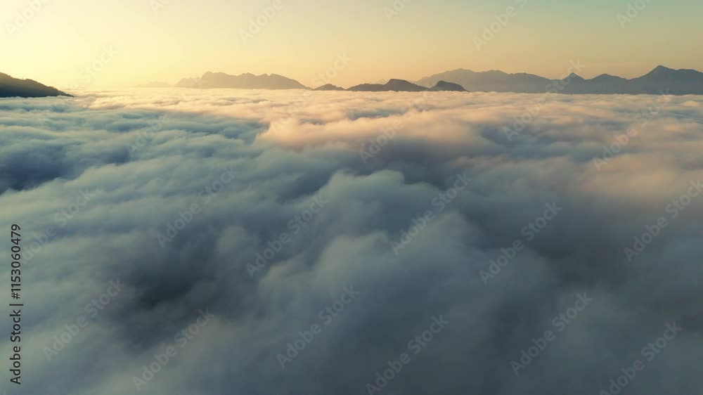 Aerial overview of tranquil clouds glowing with golden light at high altitude during sunset Aerial overview of tranquil clouds glowing with golden light at high altitude during sunset