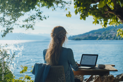 Fototapeta Naklejka Na Ścianę i Meble -  Woman enjoying a remote work setup with peaceful lake views.