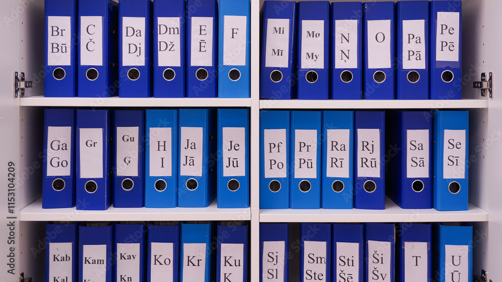 Registry or archive in blue file binders alphabetical order in latvian. Alphabetical file document system for patient medical records or cards. Registry or archive in blue file binders alphabetical order in latvian. Alphabetical file document system for patient medical records or cards.