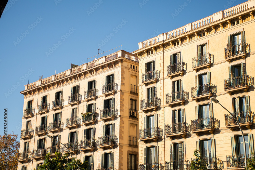 historic hotel building facade with open windows facing the sun on a beautiful and clear day in barcelona in spain historic hotel building facade with open windows facing the sun on a beautiful and clear day in barcelona in spain