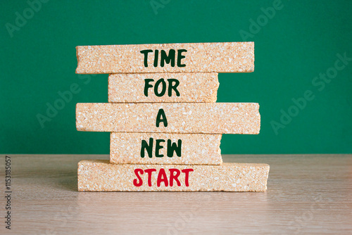 Time for a new start symbol. Concept words Time for a new start on brick blocks. Beautiful green background, wooden table. Business and Time for a new start concept.