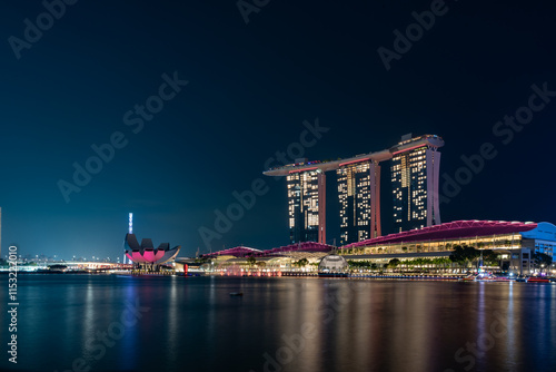 Panoramic Night View Of The Marina Bay Sands Hotel In Singapore Illuminated by Purple Lights