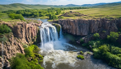 Bird eye view of the Ulaan Tsutgalan Waterfall, with water cascading into a rocky gorge surrounded by lush greenery, in 4K resolution