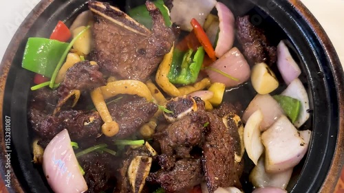 Stirring and cooking beef an vegetables in a frying pan. Close up view. Meat is fried in a pan with steam