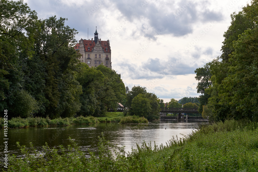 Picturesque Schloss Hohenzollern Castle Overlooking Tranquil River and Historic Bridge in Scenic German Countryside Picturesque Schloss Hohenzollern Castle Overlooking Tranquil River and Historic Bridge in Scenic German Countryside