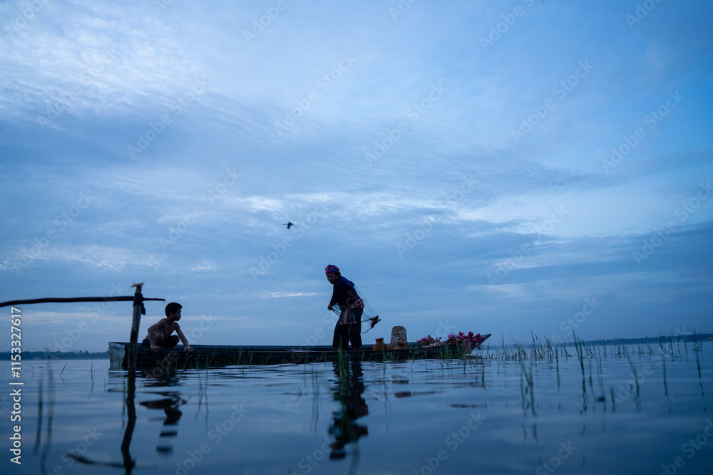 Fisherman casting his net at sunrise. Silhouette Asian fisherman on wooden boat casting a net in the Lake. Vietnamese Fisherman throwing net. Fisherman casting his net at sunrise. Silhouette Asian fisherman on wooden boat casting a net in the Lake. Vietnamese Fisherman throwing net.