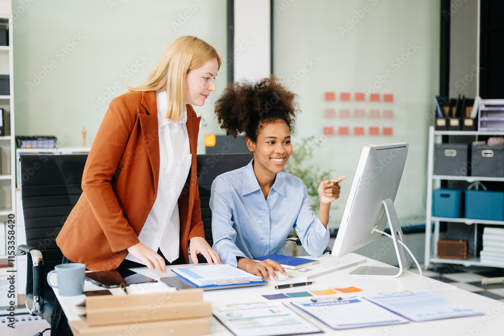 Female discussing new project with Female colleague. Young woman talking with young african woman Female discussing new project with Female colleague. Young woman talking with young african woman