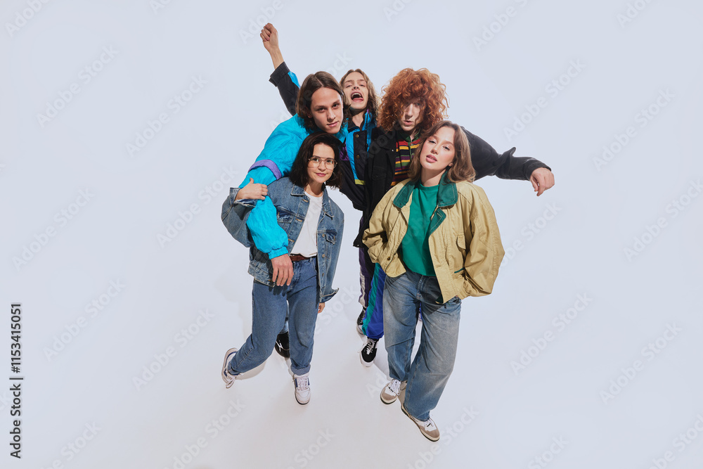 Five young stylish people, men and women in their 20s wearing stylish retro inspired outfits, posing against white studio background. Concept of 90s fashion, retro style, youth