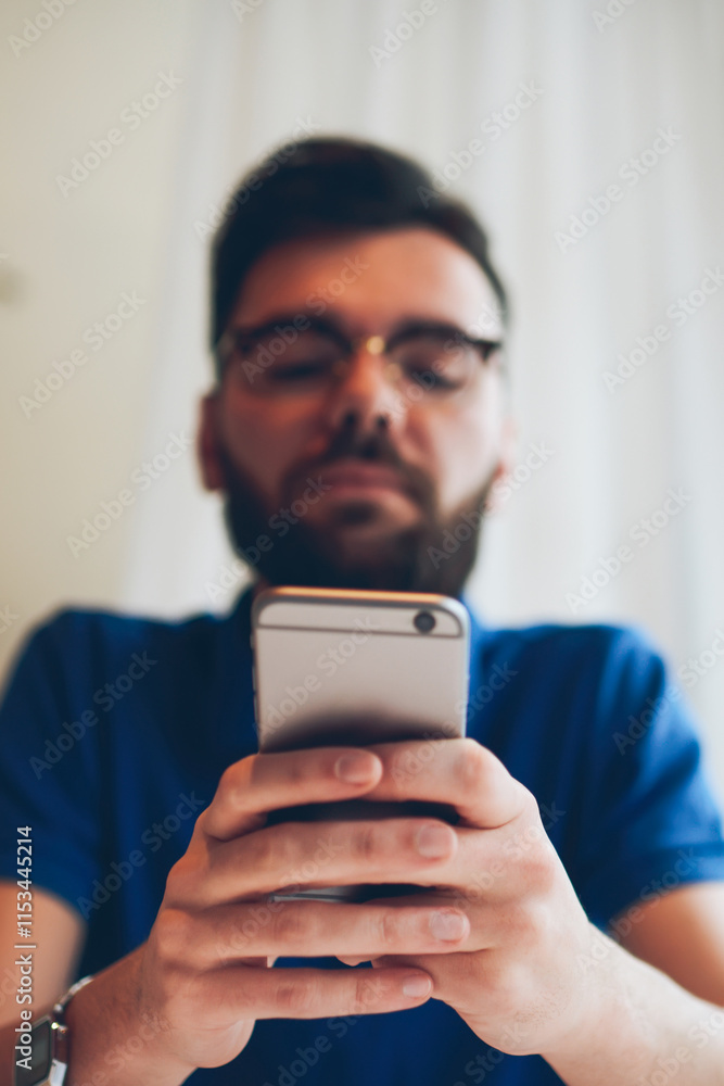 Selective focus on smartphone, young skilled hipster guy chatting with friends in social networks and checking mail via modern mobile phone with 4g connection while waiting friend Selective focus on smartphone, young skilled hipster guy chatting with friends in social networks and checking mail via modern mobile phone with 4g connection while waiting friend