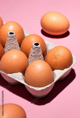 Eggs in a tray on pink background