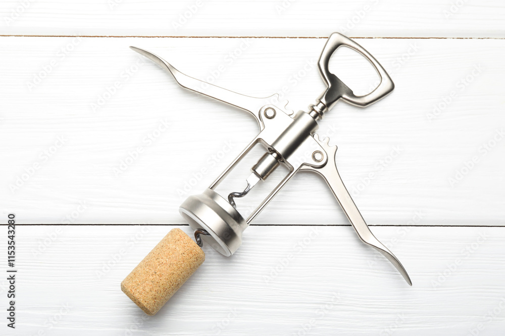 Wing corkscrew and cork on white wooden table, top view Wing corkscrew and cork on white wooden table, top view