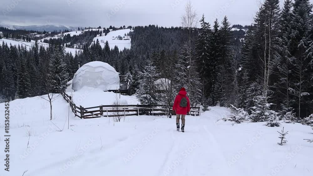 Woman blogger walking near dome hotel in mountains in winter with snow. Woman blogger walking near dome hotel in mountains in winter with snow.