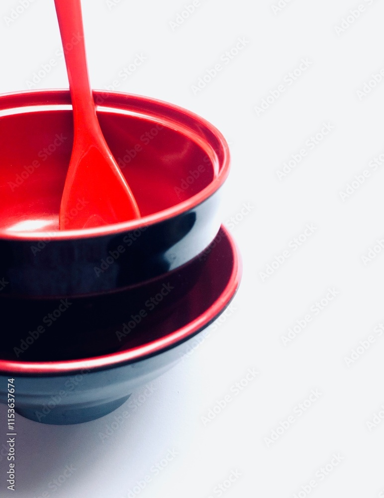 Red ceramic spoon with red bowls on white background Red ceramic spoon with red bowls on white background