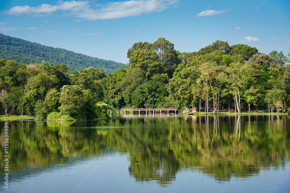 Fototapeta premium Ang Kaew reservoir with forest and lake reflection on sunny day