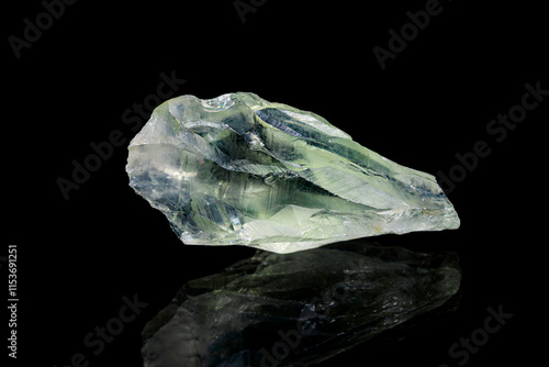 Rough prasiolite (vermarine, green quartz, green amethyst) gemstone on dark background (selective focus)