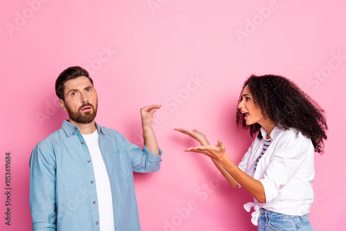 Obraz na plátně Young couple arguing with expressive gestures against a vibrant pink backdrop in