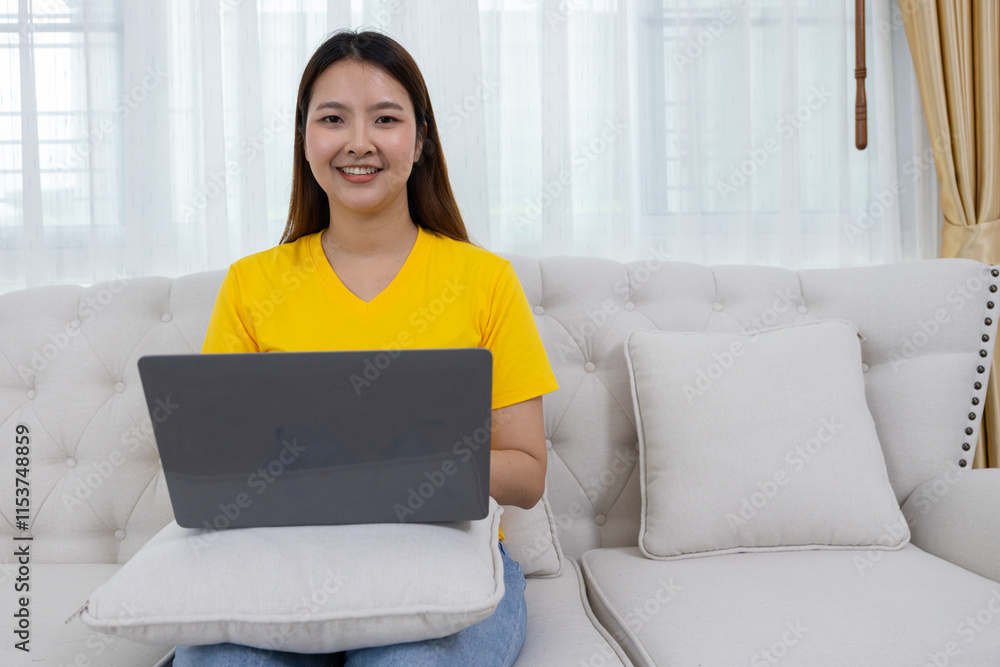 Naklejka premium Smiling Woman Using Laptop on Couch