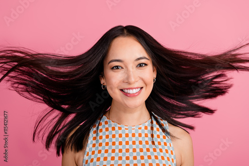 Photography Joyful young woman flipping her hair against a vibrant pink background in a trendy outfit, exuding happiness and confidence