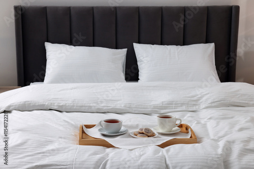 Breakfast tray on bed with beautiful linens indoors photo