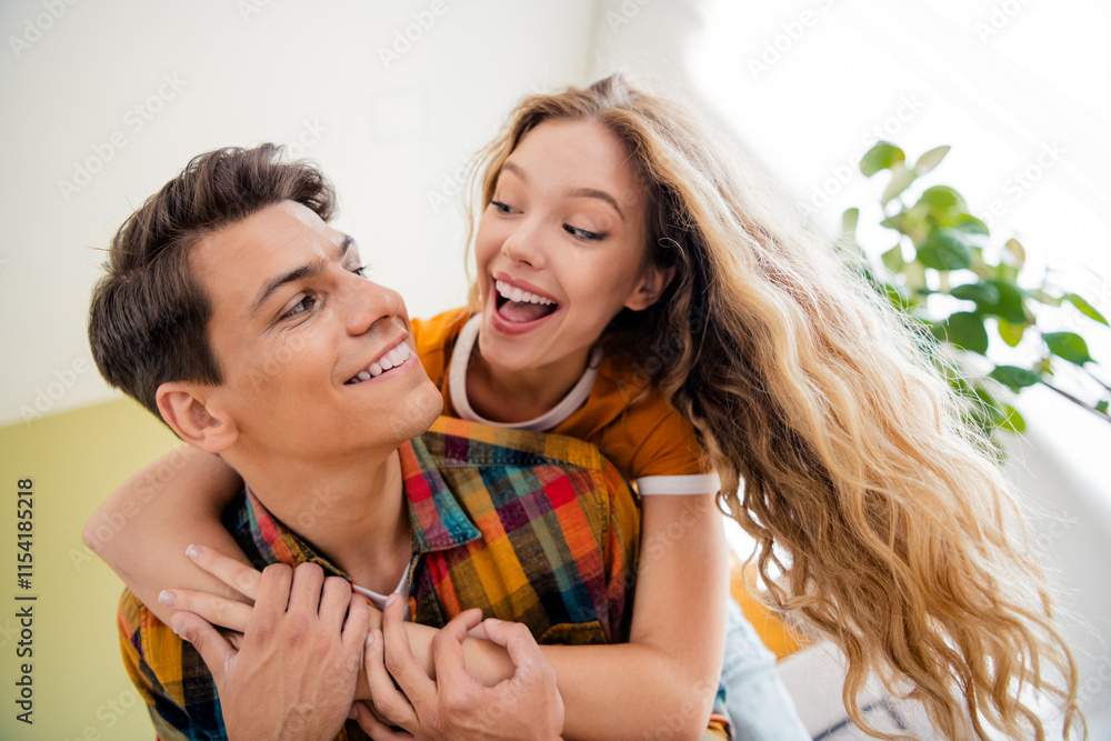 Photo of cute young couple have fun cuddle piggyback cozy day light spring summer home interior living room