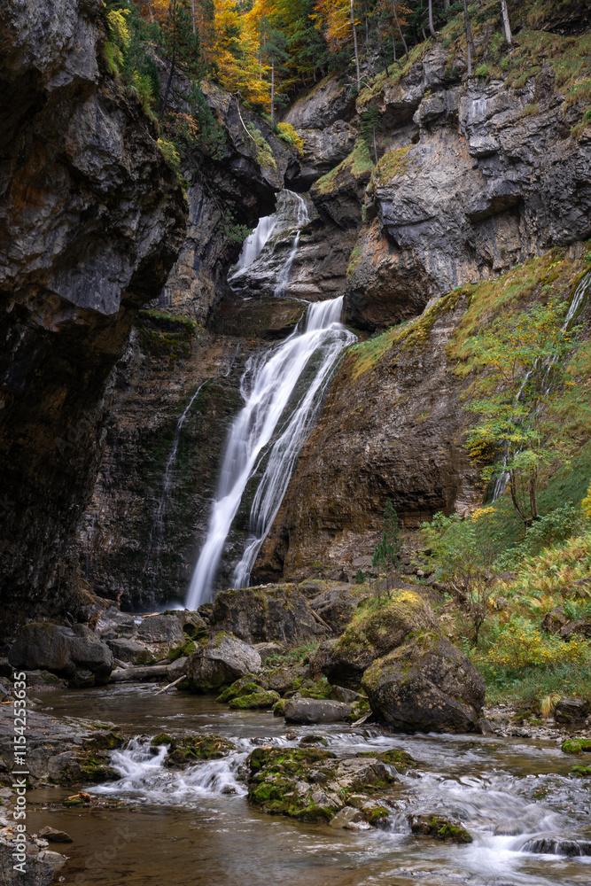 Waterfall of the strait (Estrecho waterfall) in autumn in the Ordesa Valley National Park in Aragon Pyrenees. Huesca, Spain. Ara river waterfalls. Waterfall of the strait (Estrecho waterfall) in autumn in the Ordesa Valley National Park in Aragon Pyrenees. Huesca, Spain. Ara river waterfalls.