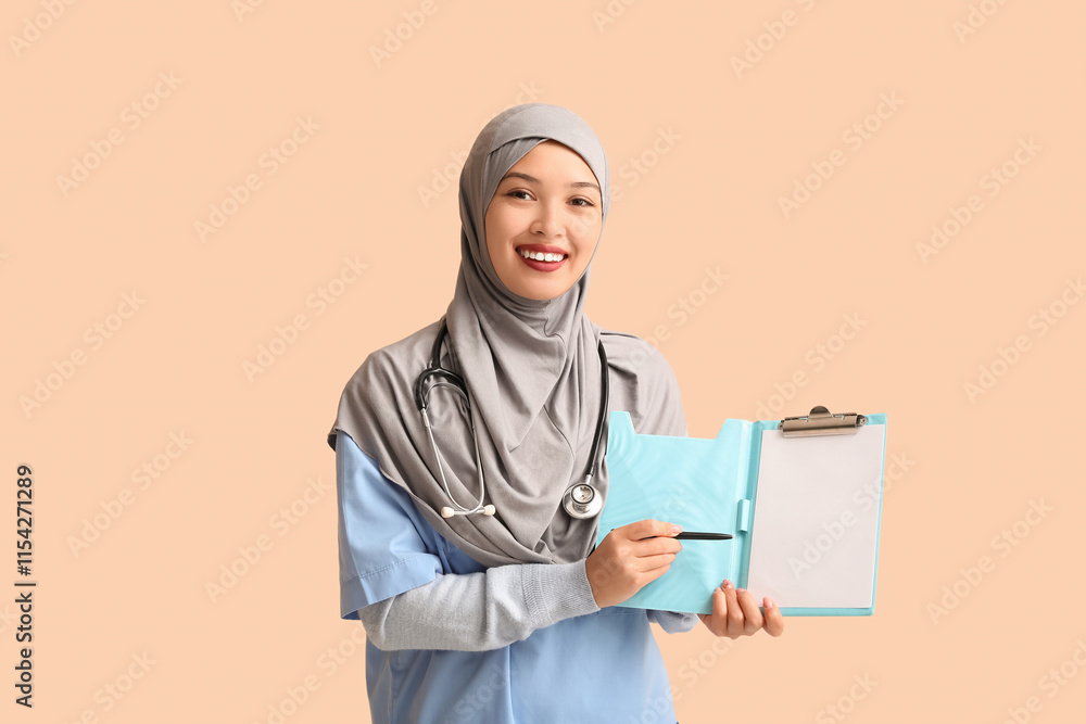 Female Muslim doctor in hijab with clipboard on beige background. World Hijab Day concept Female Muslim doctor in hijab with clipboard on beige background. World Hijab Day concept