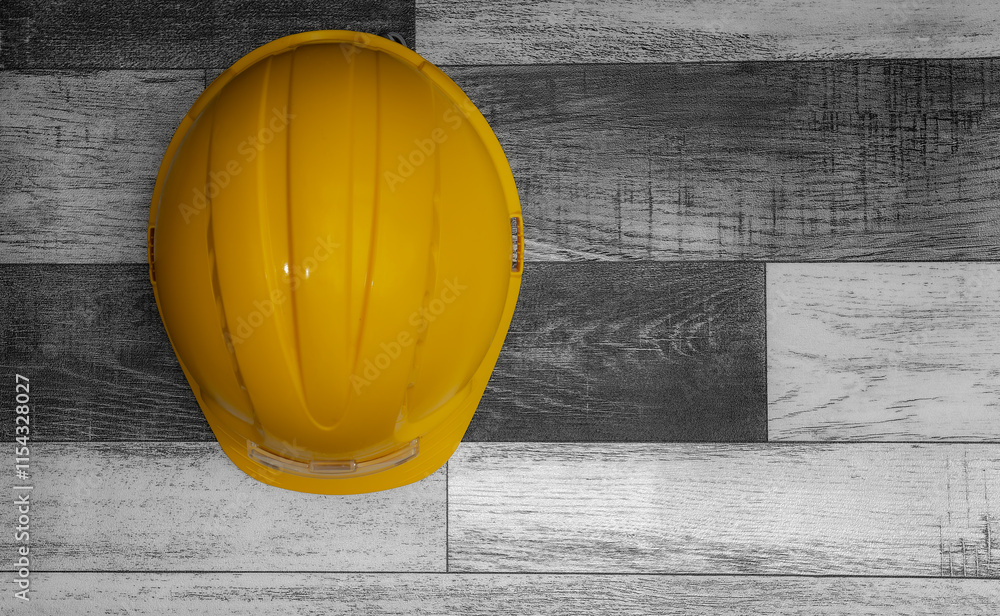 Yellow hard hat resting on wooden surface with copy space