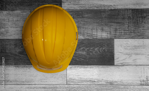 Yellow hard hat resting on wooden surface with copy space