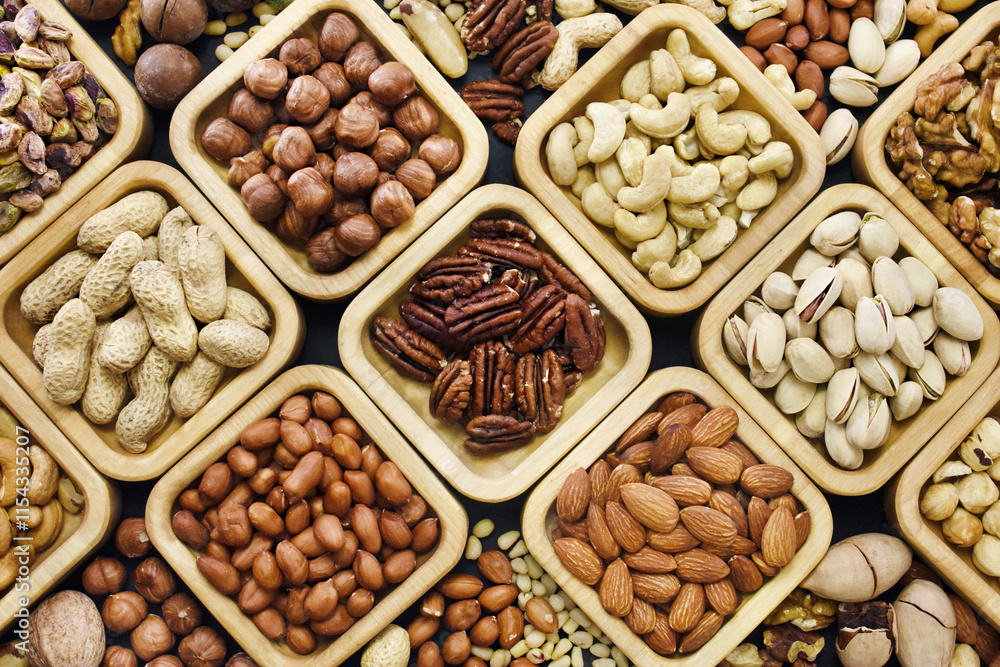 Colorful mix of various nuts: peanut and cashew, hazelnut and almond, pine nuts and walnut; healthy diet snack; vegan food background, selective focus, shallow focus Colorful mix of various nuts: peanut and cashew, hazelnut and almond, pine nuts and walnut; healthy diet snack; vegan food background, selective focus, shallow focus