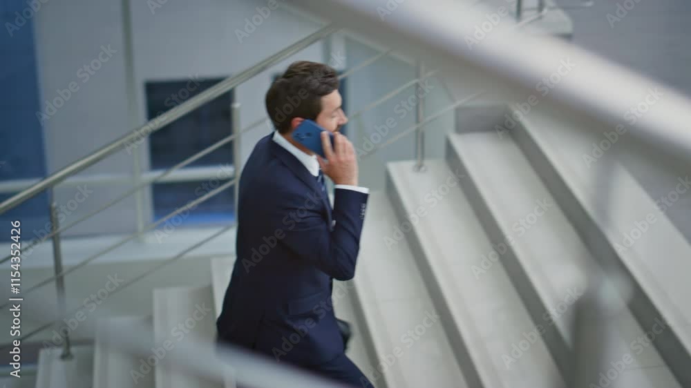 Calling manager going upstairs light building with briefcase. Man talking phone Calling manager going upstairs light building with briefcase. Man talking phone