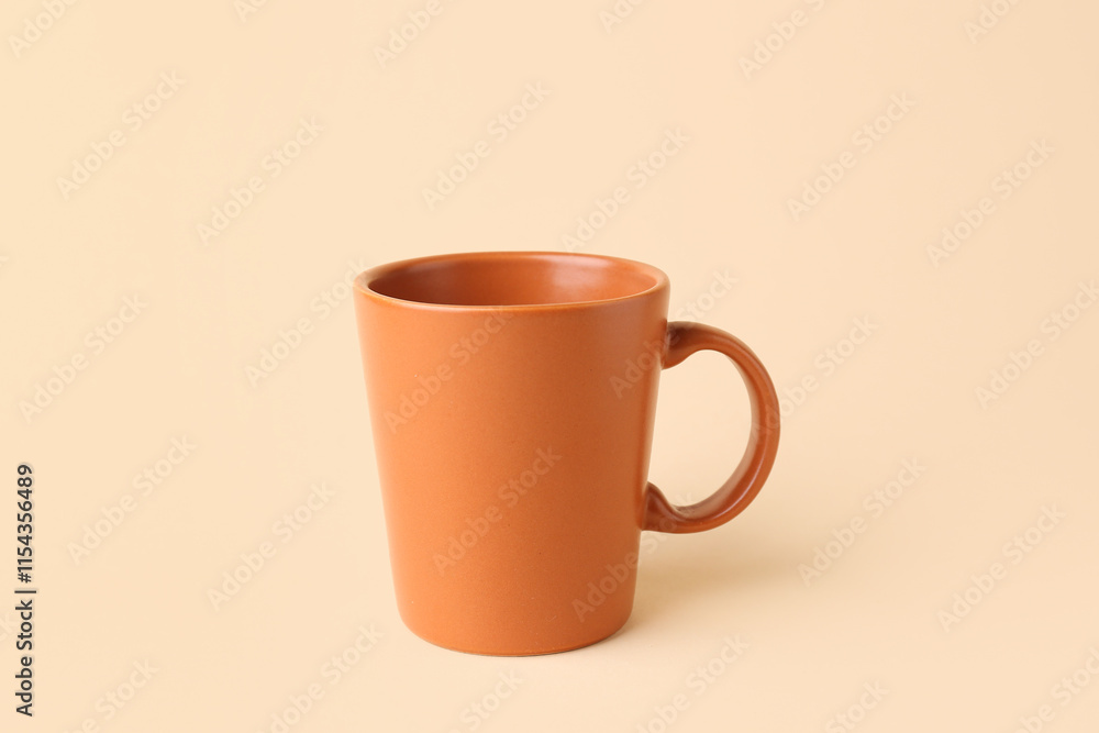 Brown ceramic cup on beige background Brown ceramic cup on beige background