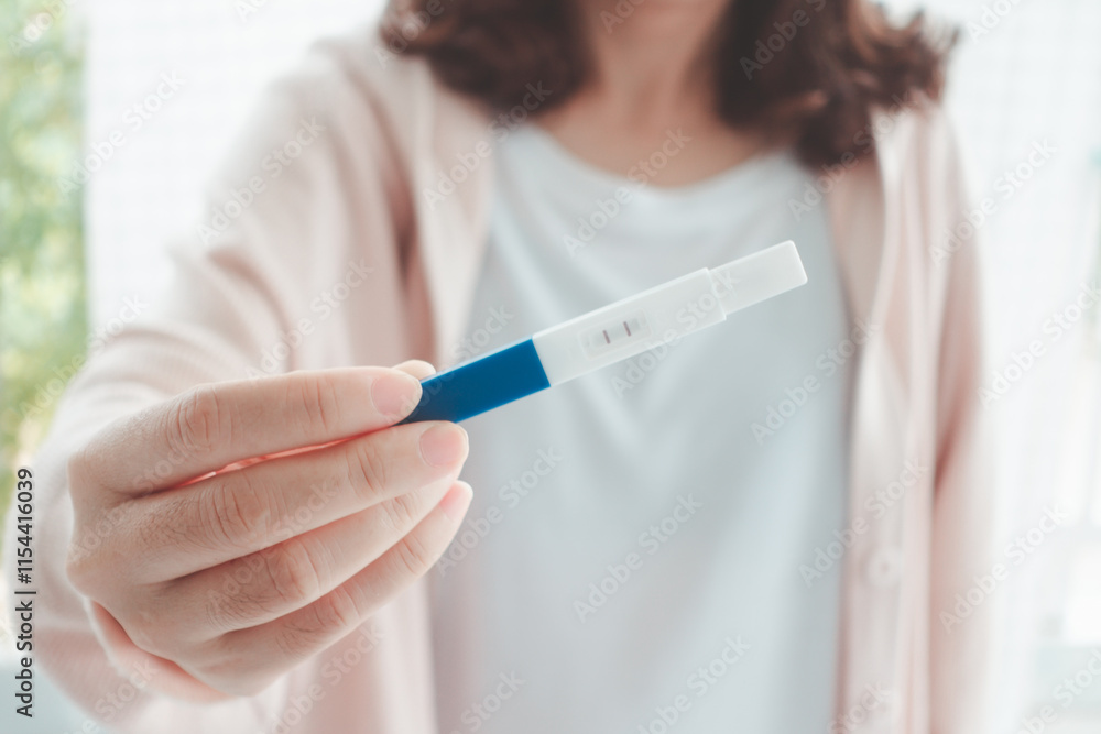 Happy pregnant woman holding a positive result pregnancy test with two stripes at home. Conception of a child. Family planning. wellness and healthy concept. Happy pregnant woman holding a positive result pregnancy test with two stripes at home. Conception of a child. Family planning. wellness and healthy concept.