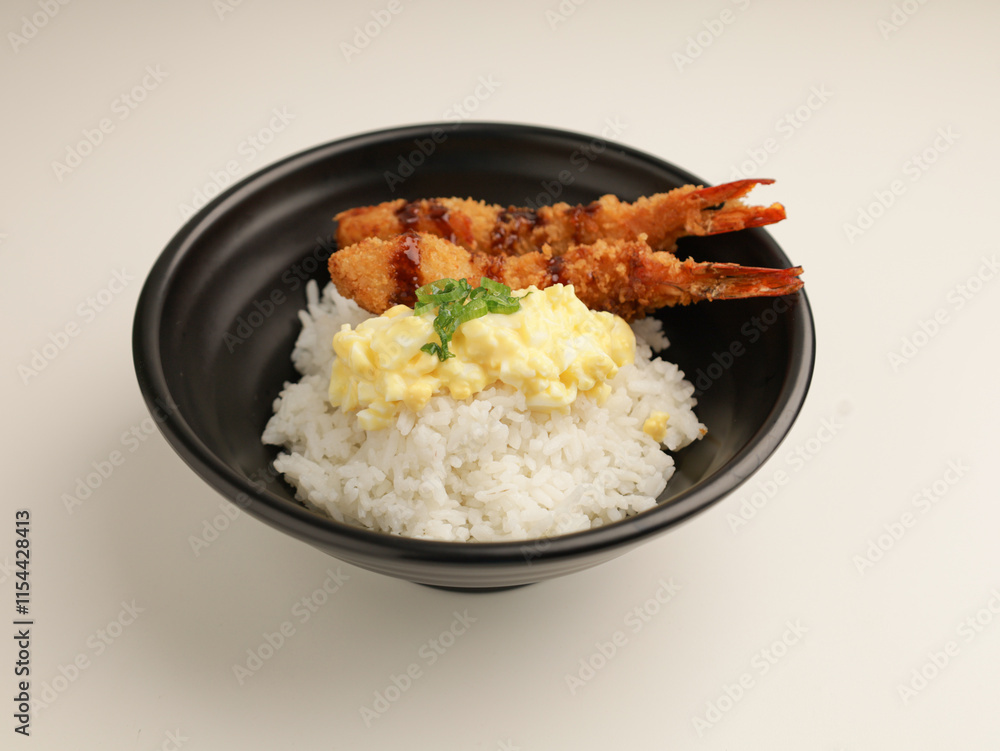 rice with fried shrimp and teriyaki sauce served with egg mayonnaise in black bowl rice with fried shrimp and teriyaki sauce served with egg mayonnaise in black bowl