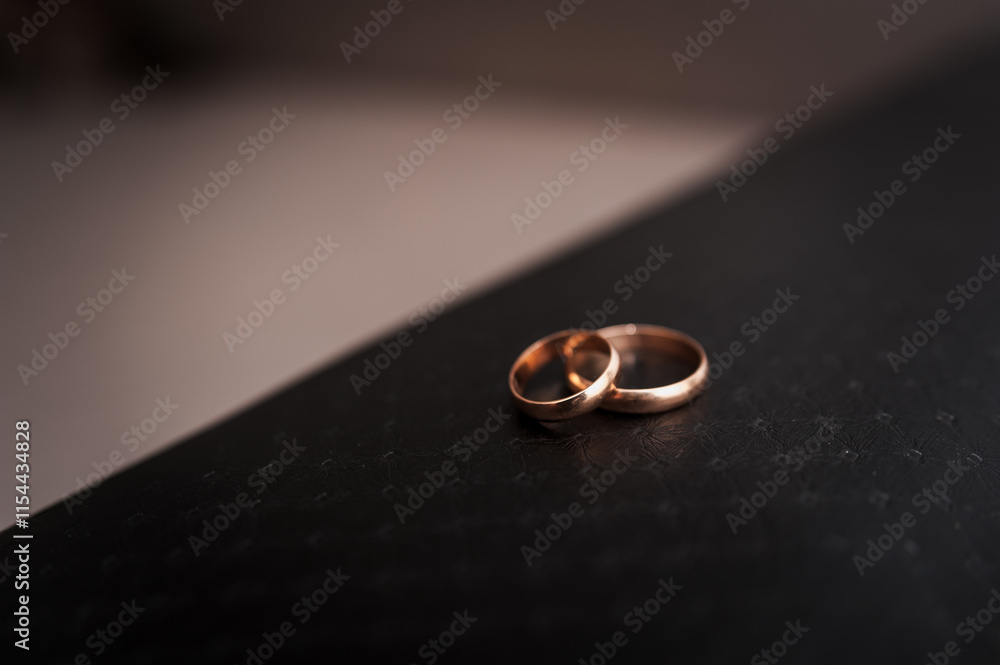 Elegant Rose Gold Wedding Rings on a Dark Surface Elegant Rose Gold Wedding Rings on a Dark Surface