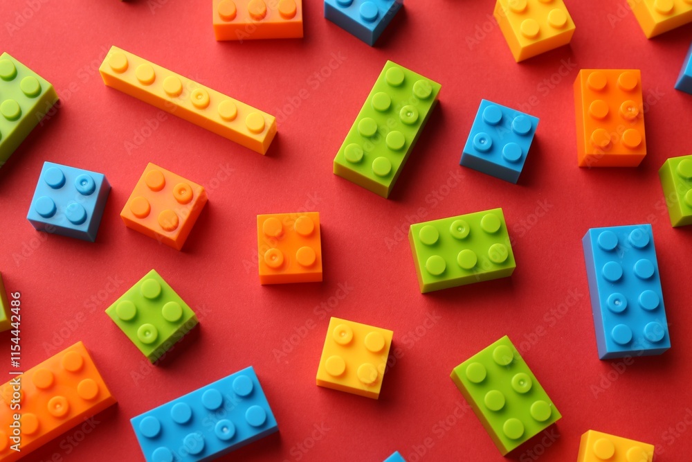 Obraz premium Construction toy. Colorful building bricks on red background, above view