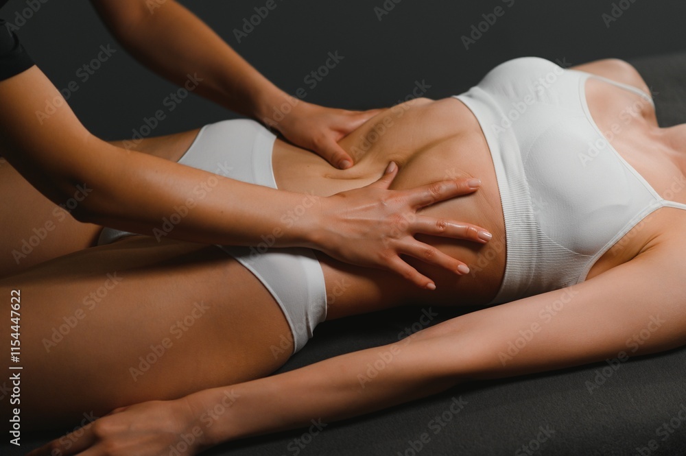 Young woman receiving abdominal massage in spa salon Young woman receiving abdominal massage in spa salon
